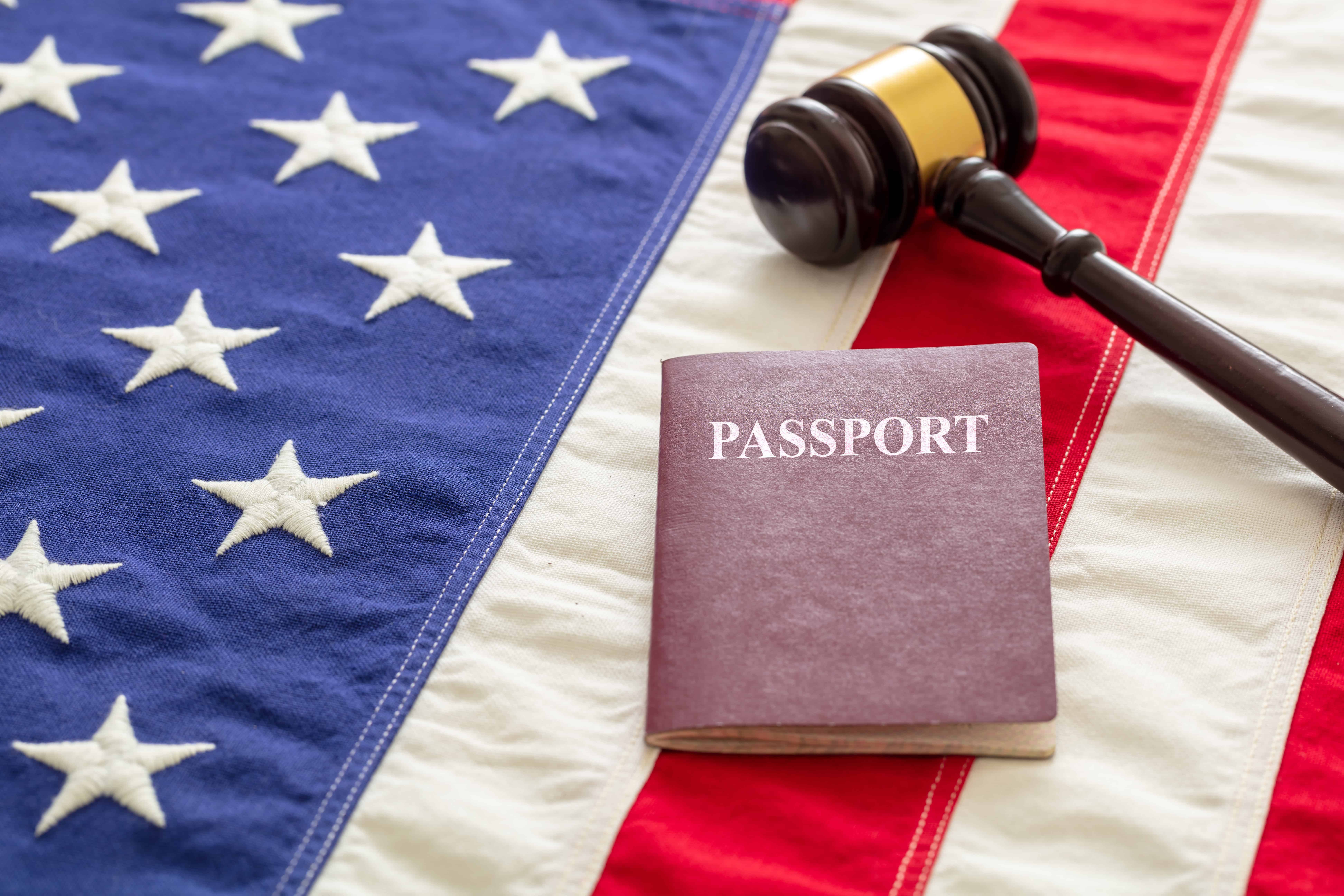 Passeport et marteau de loi sur fond de drapeau américain, vue rapprochée.