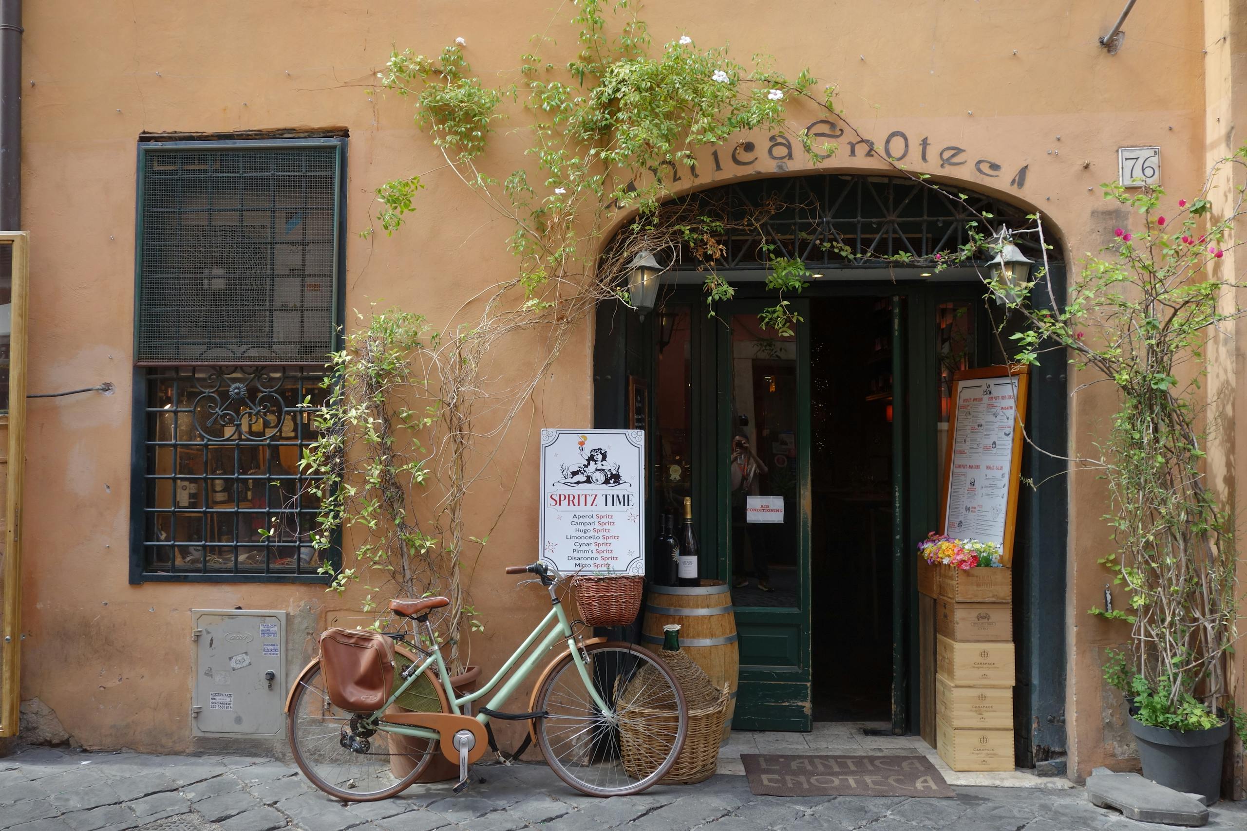 Italian enoteca entrance with a vintage bicycle and rustic decor.