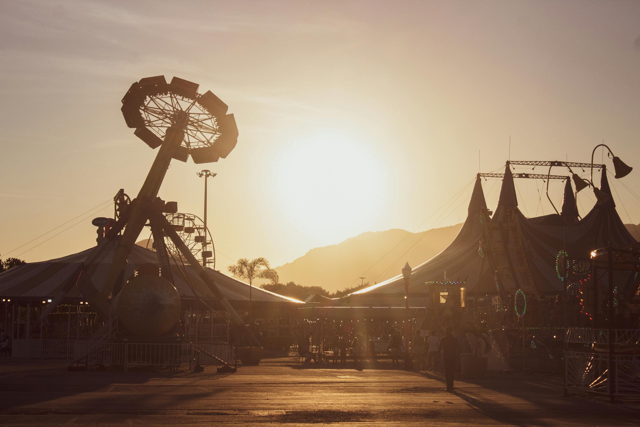 A stunning view of amusement rides at sunset casting warm tones across a lively fairground. coachella