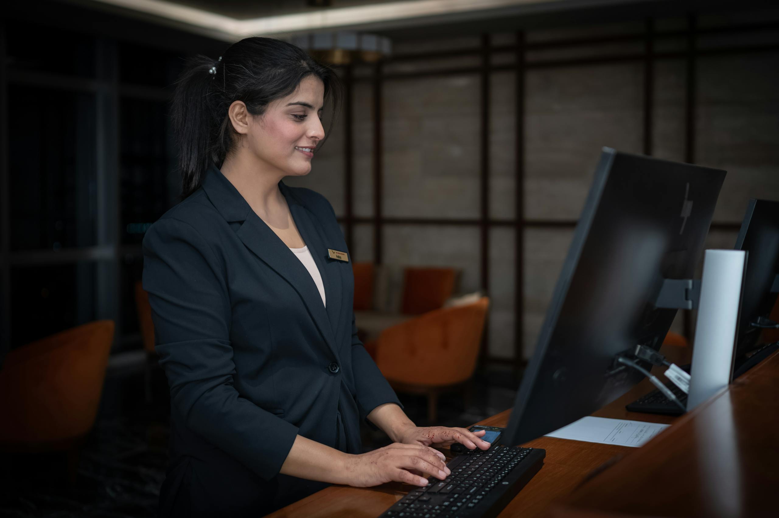 A female hotel manager working at a hotel front desk