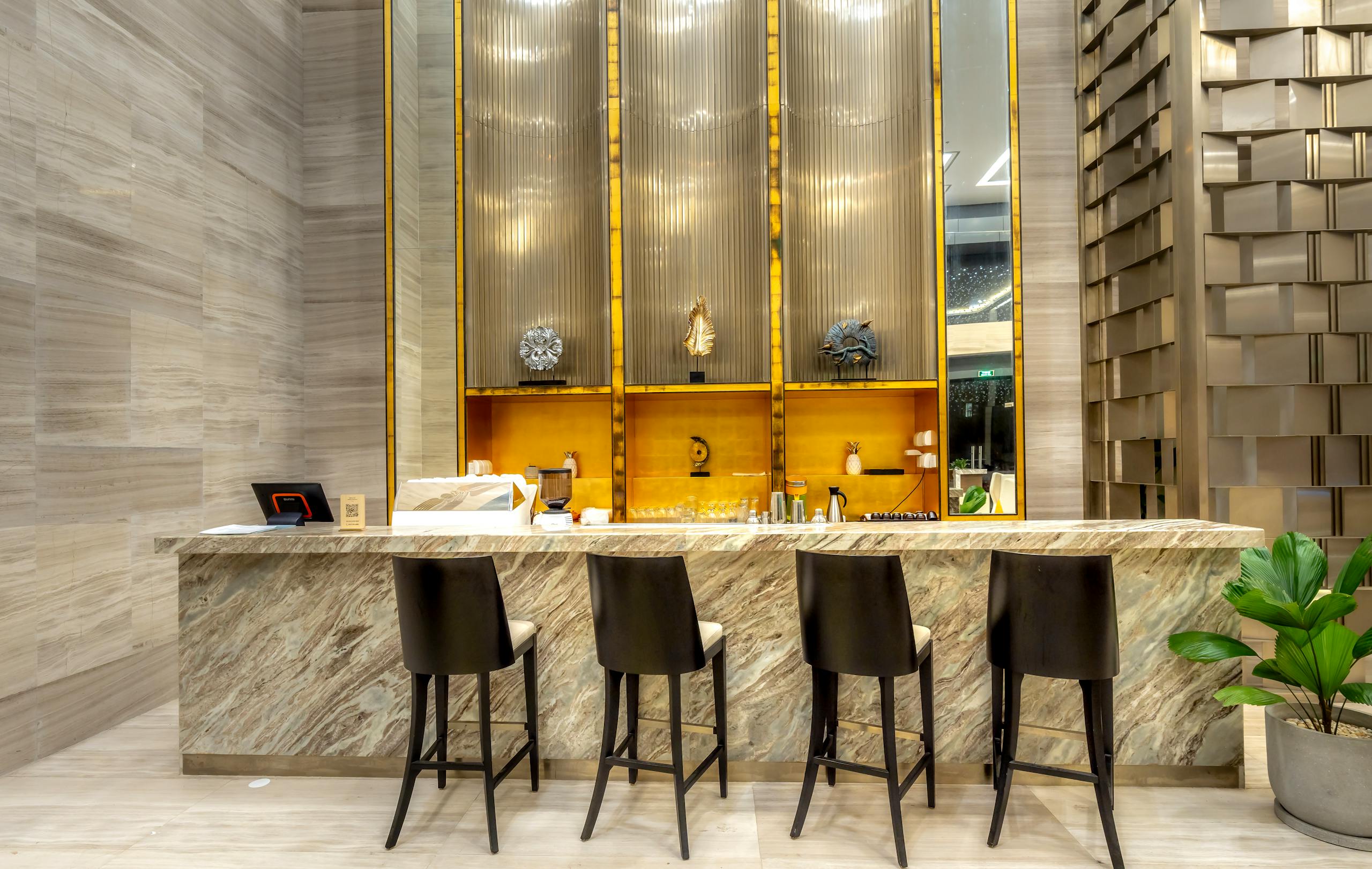 A luxurious and modern bar counter with stylish stools in a hotel's elegant interior design. luxury hospitality