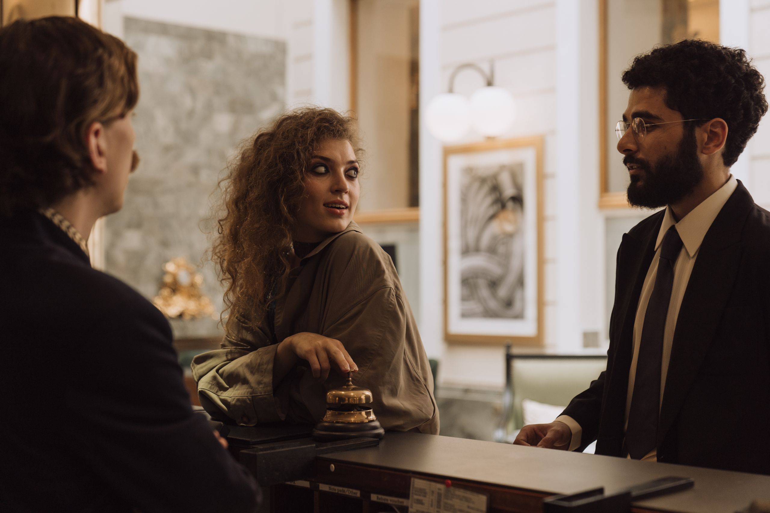Guests interacting at a luxurious hotel reception desk, emphasizing hospitality trends and service.